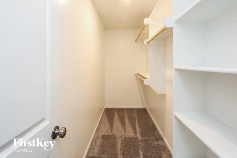 a walk in closet with shelves and a door
