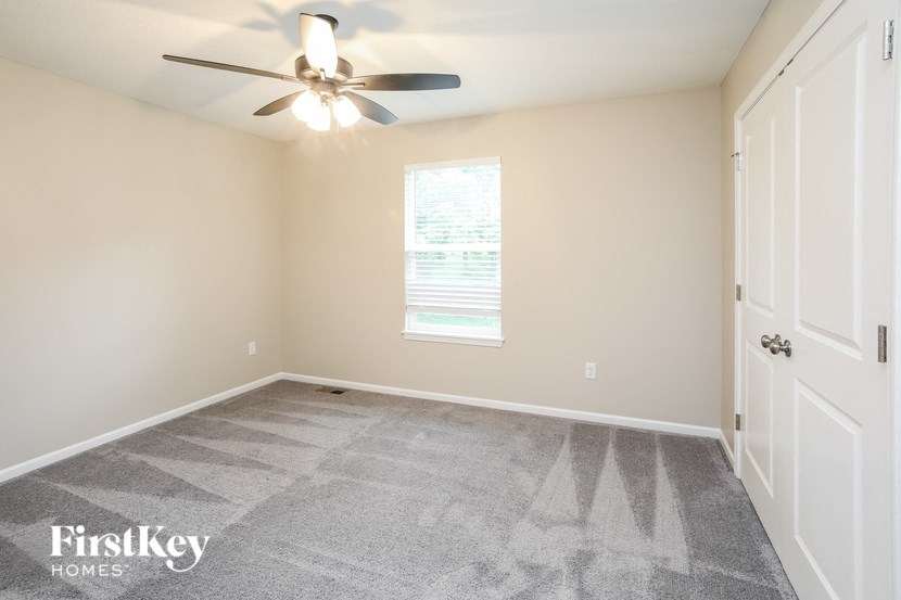 a bedroom with carpet and a ceiling fan