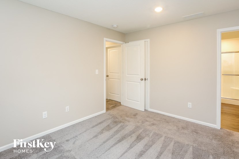 a bedroom with a carpeted floor and a door to a closet