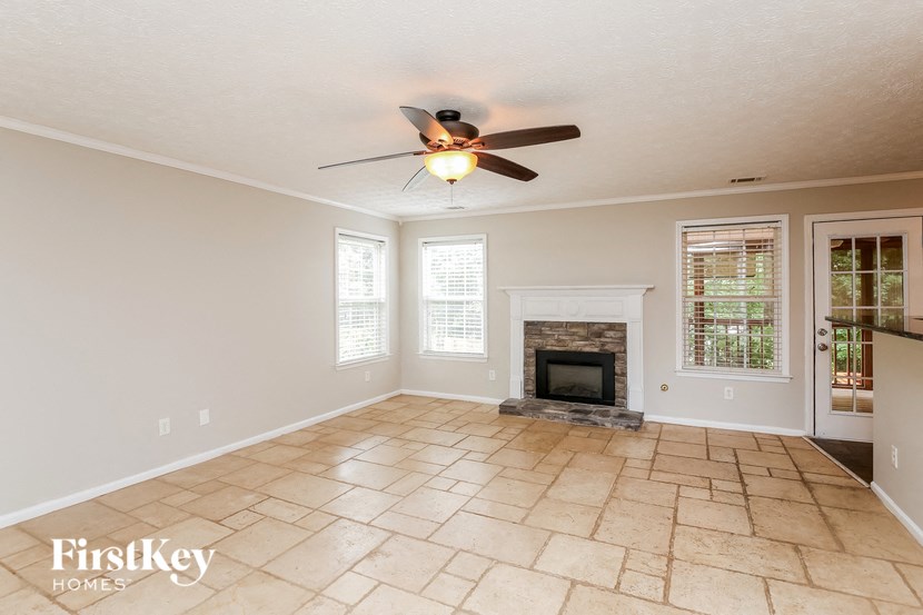 a living room with a fireplace and a ceiling fan
