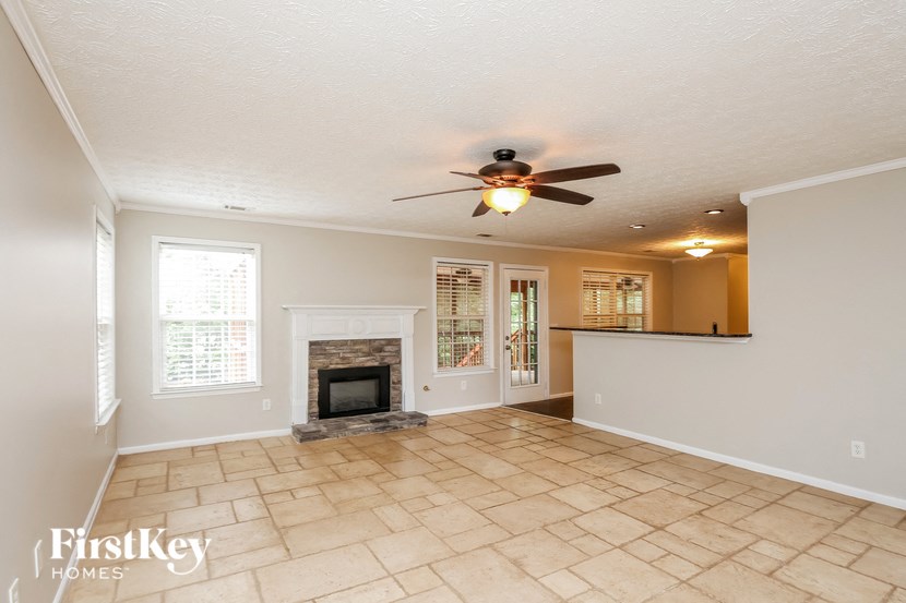a living room with a fireplace and a ceiling fan