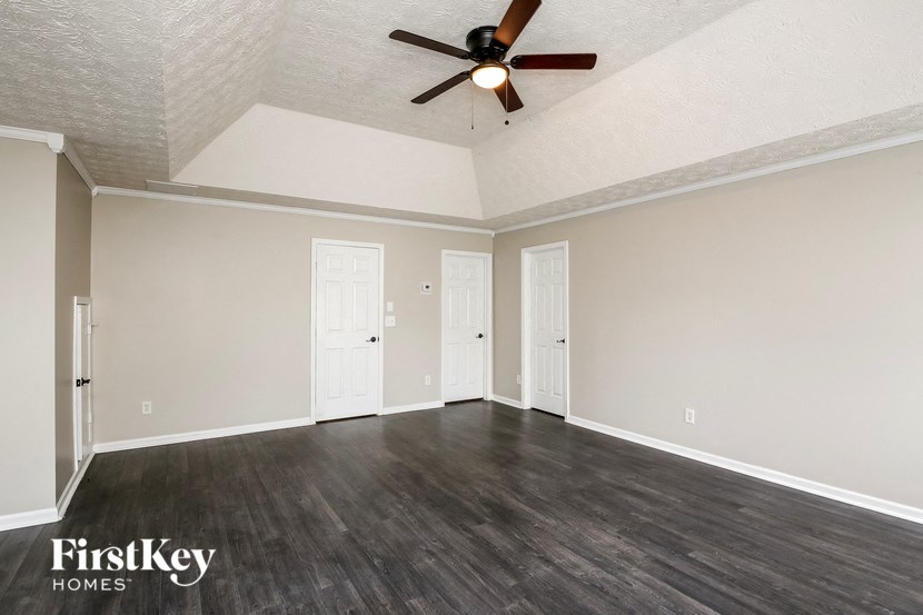 the living room of an empty house with a ceiling fan