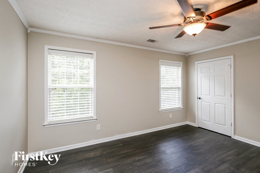the living room of an empty house with a ceiling fan