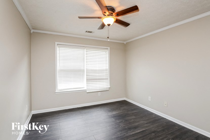 a empty room with a ceiling fan and a window