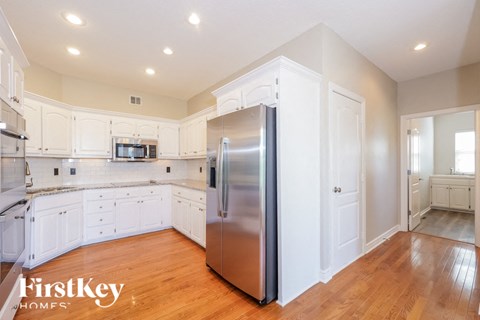 a kitchen with white cabinets and a stainless steel refrigerator