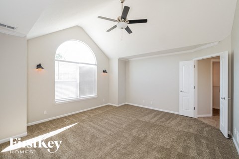 the living room with carpet and a ceiling fan