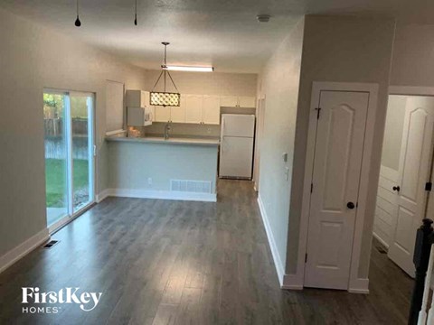 A kitchen area with a sink and a refrigerator in a house.