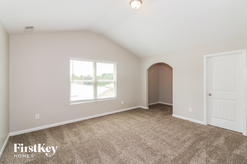 the living room of a home with carpet and a window