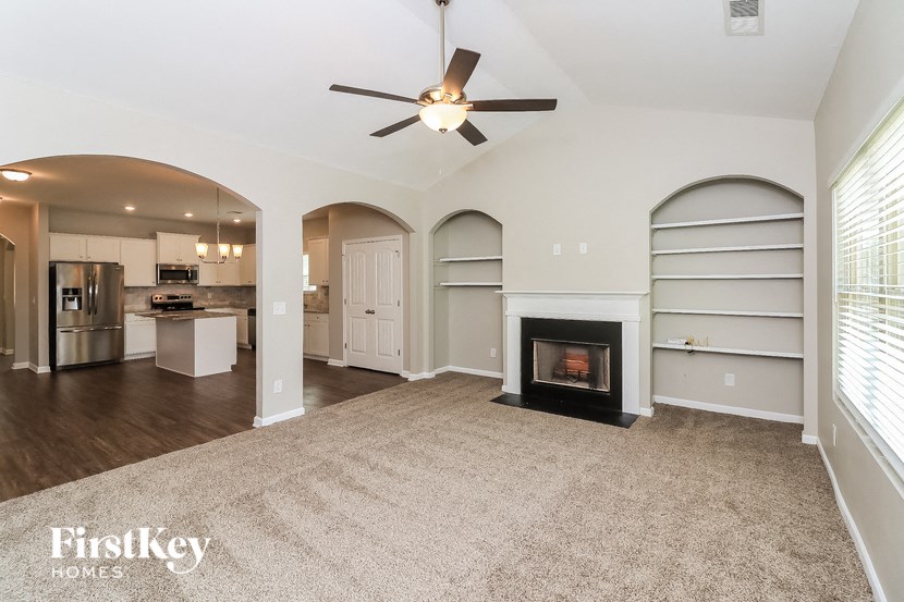 a living room with a fireplace and a kitchen