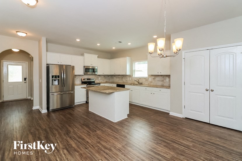 a kitchen with white cabinets and a stainless steel refrigerator