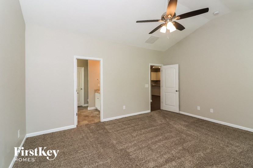 an empty living room with carpet and a ceiling fan