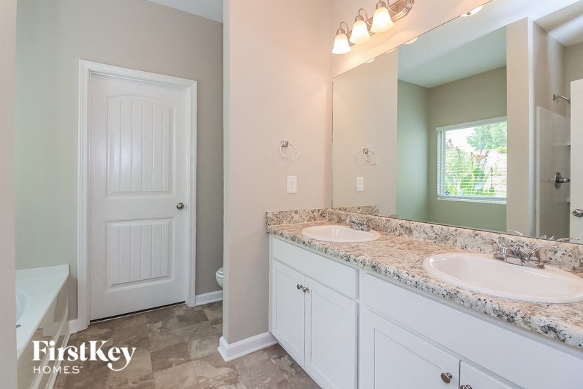 a bathroom with two sinks and a toilet and a mirror
