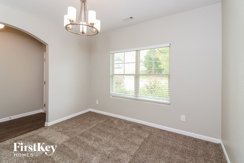 a living room with a large window and a carpet