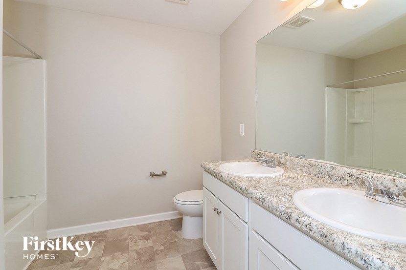 a bathroom with two sinks and a shower and a toilet