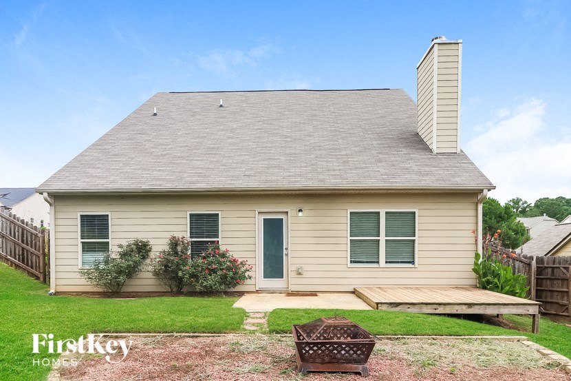 the front of a small house with a porch and a deck
