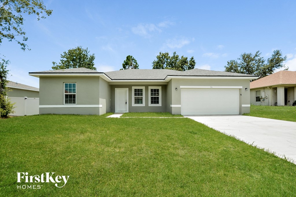 a beige house with a lawn in front of it