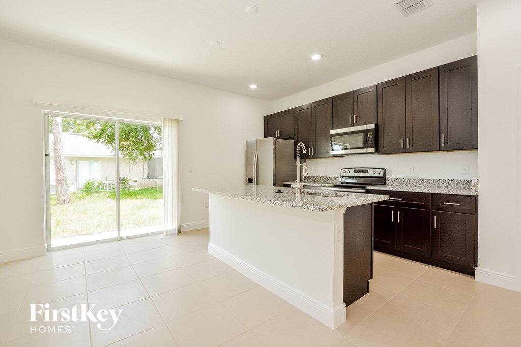 a kitchen with an island and a door to the backyard