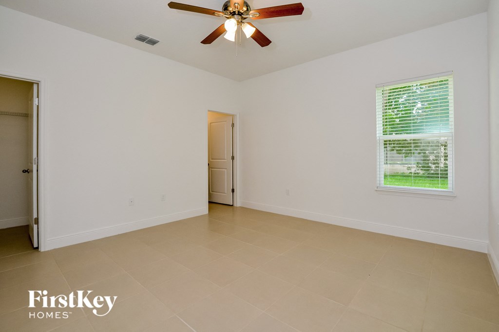 the living room of an empty house with a ceiling fan