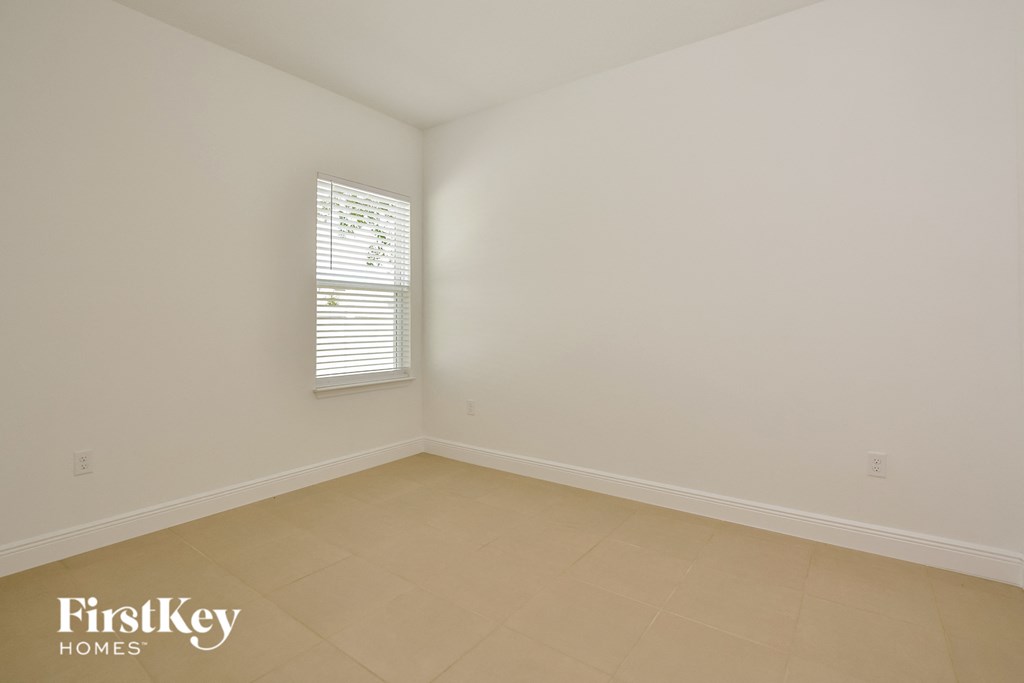 an empty room with white walls and a window