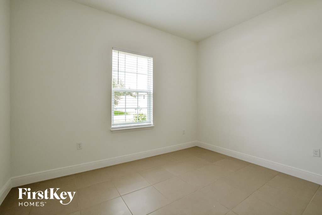 an empty room with white walls and a window
