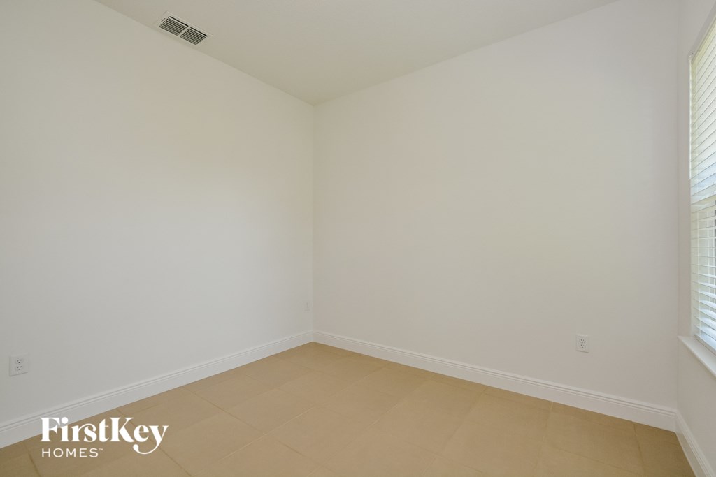 an empty room with a tiled floor and white walls