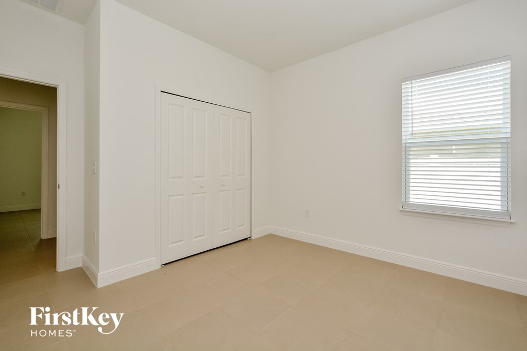 a bedroom with a door and a window and a tiled floor