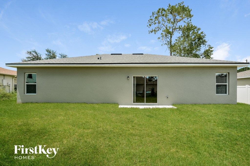 a small white house with a lawn in front of it