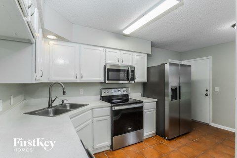a kitchen with white cabinets and stainless steel appliances