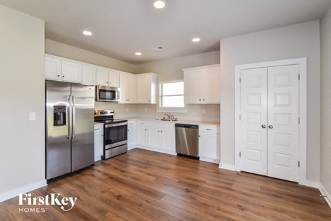 a renovated kitchen with white cabinets and stainless steel appliances