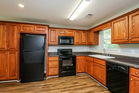 A kitchen with wooden cabinets and black appliances.