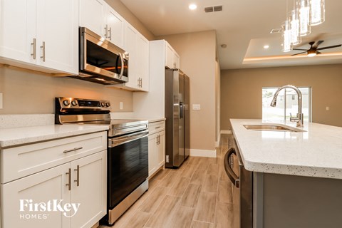 a kitchen with white cabinets and stainless steel appliances