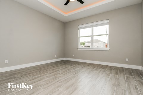 the living room with a large window and wood flooring