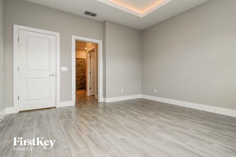 a room with a white door and a hallway with a door to a closet