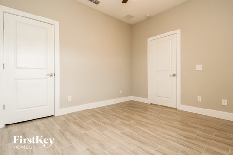 a bedroom with two doors and a wood floor