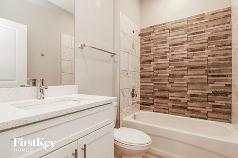 a bathroom with a toilet and a tub and a sink