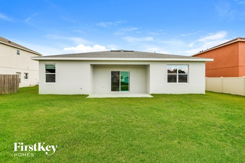 a small white house with a grassy yard in front of it