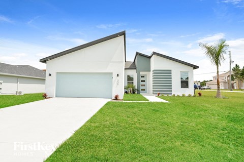 a white house with a green lawn and a garage