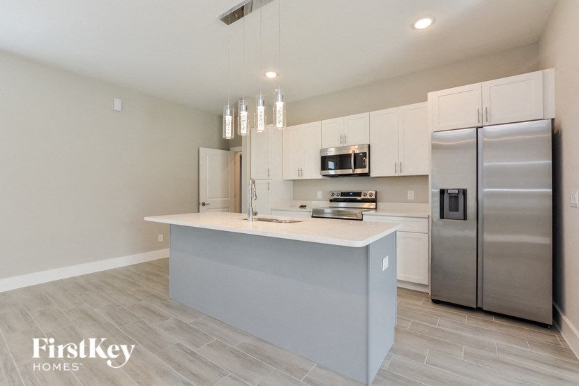 a white kitchen with stainless steel appliances and a white counter top