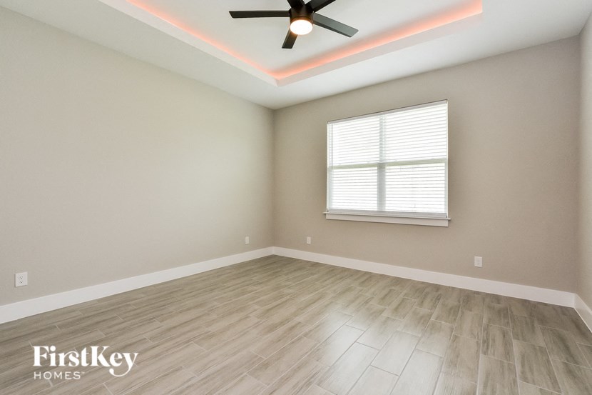 an empty room with a ceiling fan and a window