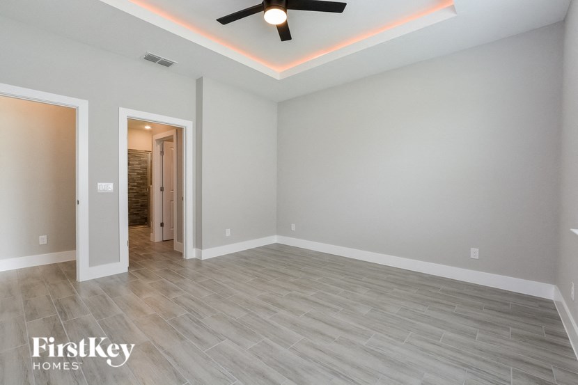 a empty living room with a ceiling fan and wood floors