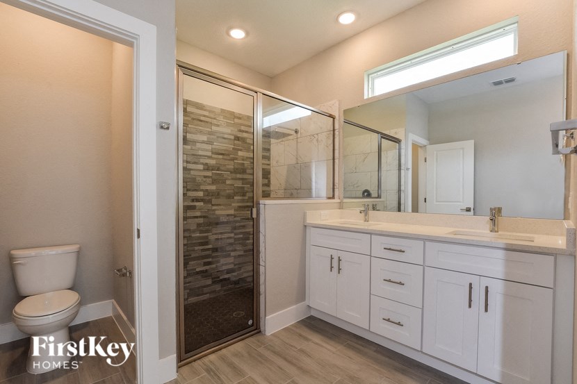 a bathroom with a toilet and a shower and a sink
