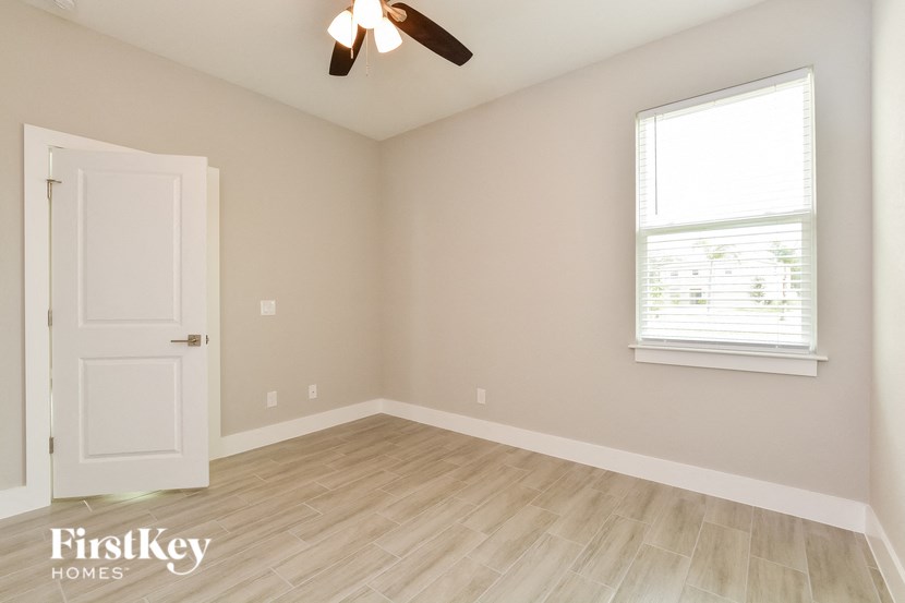 an empty room with a white door and a window