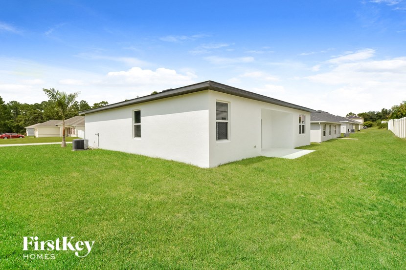 a white house with a grassy yard in front of it