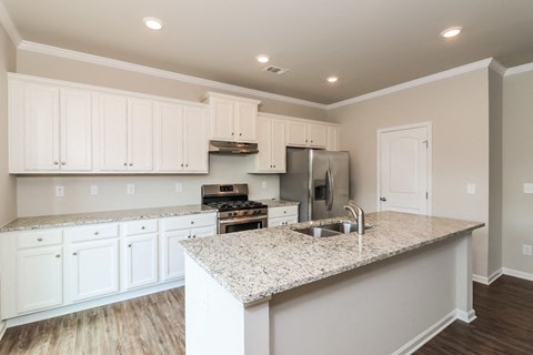 a kitchen with white cabinets and a granite counter top