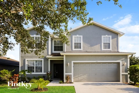 A two-story house with a garage is showcased in the image.