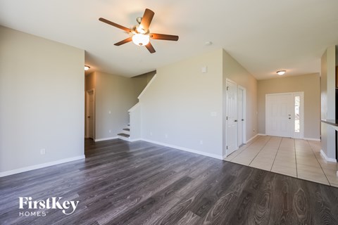 A spacious room with a wood floor and a ceiling fan.