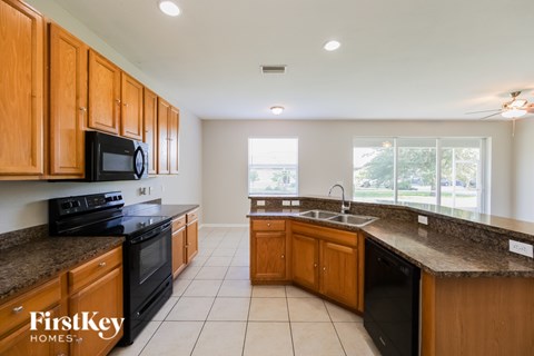 A kitchen with wooden cabinets and black appliances.