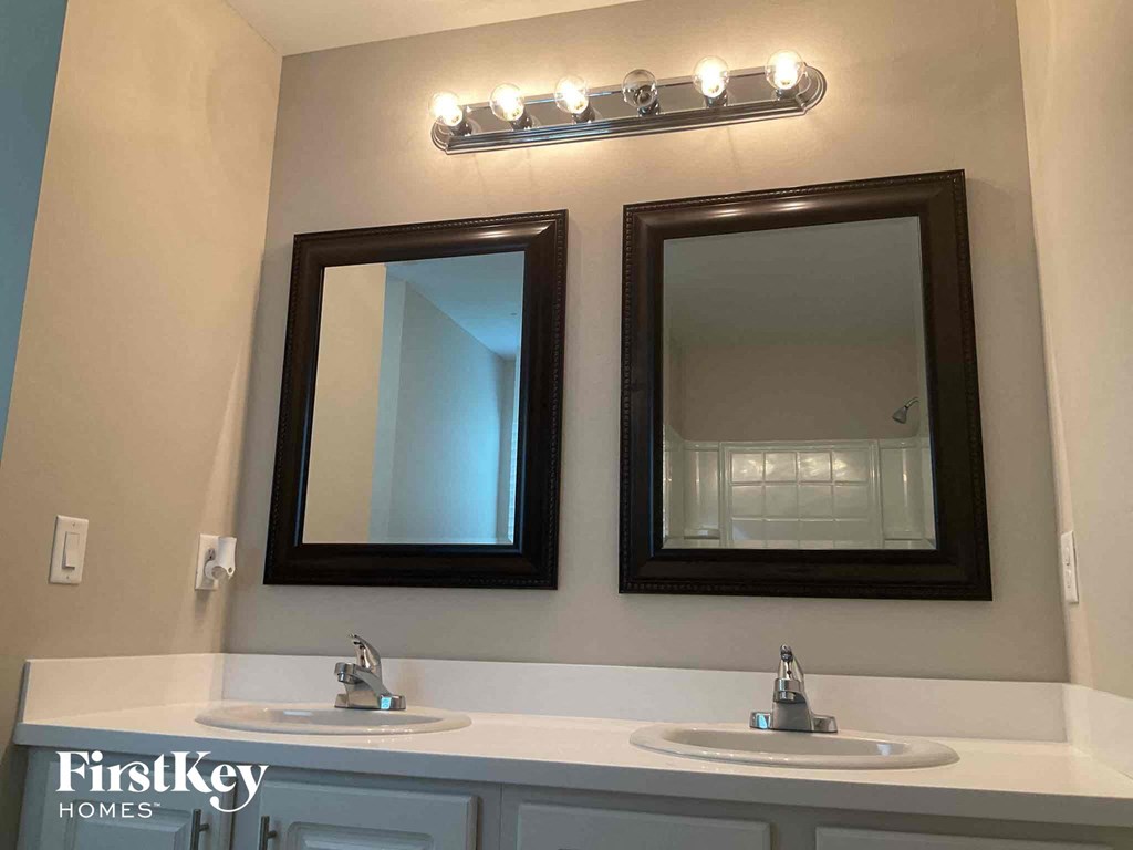 a bathroom with two mirrors and two sinks