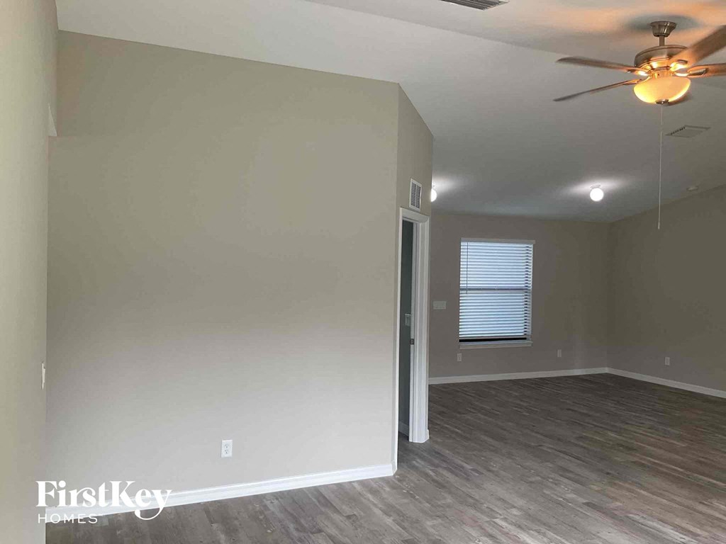 a living room with a ceiling fan and a door to a closet
