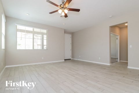 an empty living room with a ceiling fan
